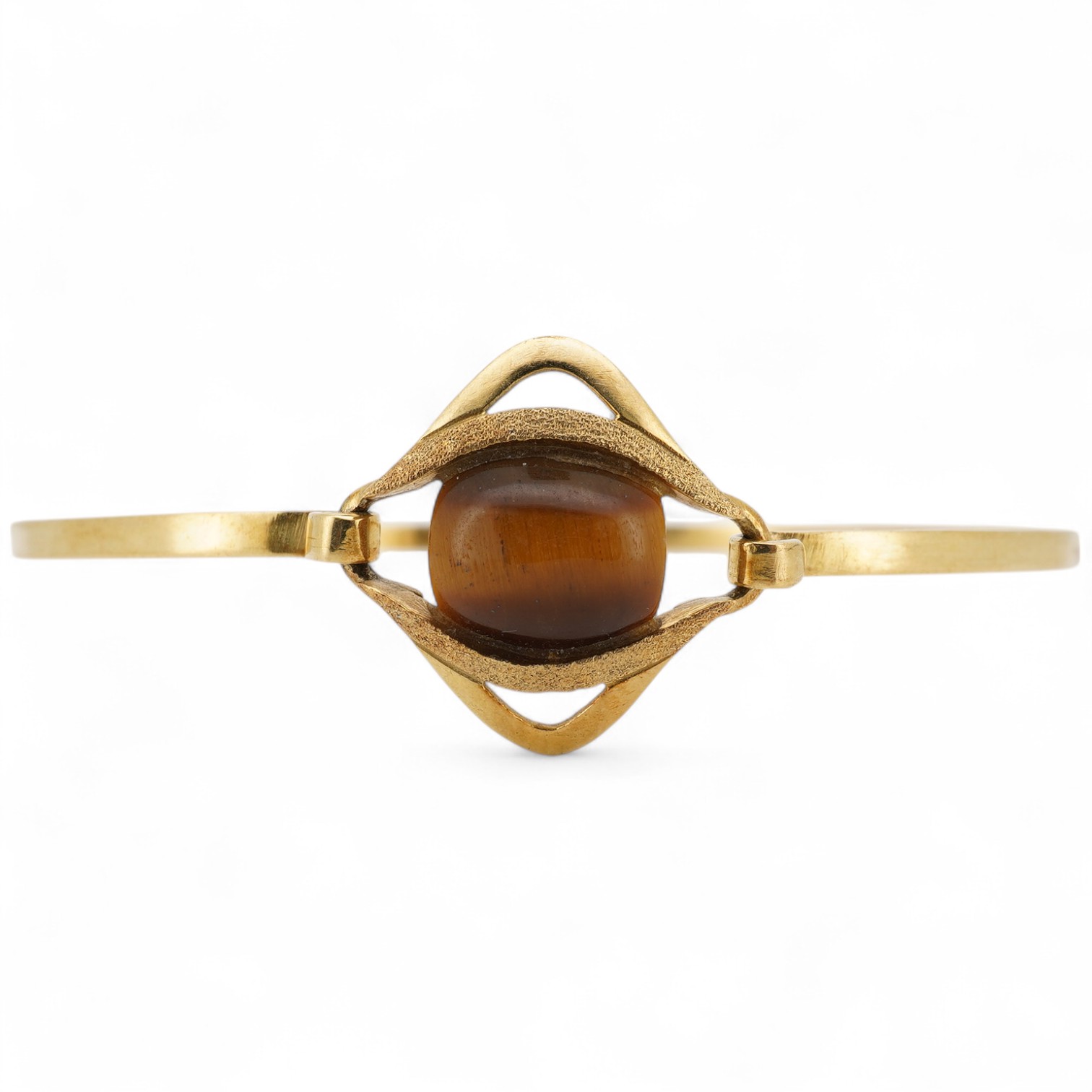 A modern continental 18k and single stone tiger's eye quartz set bangle, gross weight 7 grams.